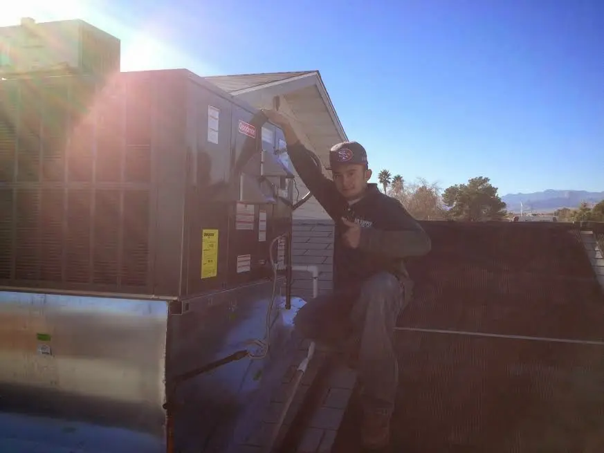HVAC technician performing Boiler Repair on a rooftop unit in Bedford